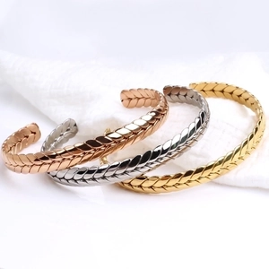 Detailed view of woven twisted wire bangles in gold, rose gold and silver finishes