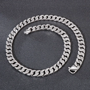 Close-up of polished silver stainless steel Cuban link necklace with lobster clasp detail