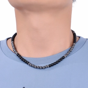 Detail of 6mm matte black and grey natural map stone beaded necklace worn on a neck