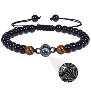 Detail of tiger eye stone bracelet featuring a circular projection stone with 100 languages