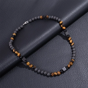 Detail of 8mm tiger eye and lava stone necklace with metal spacers on black leather