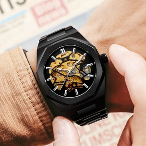 Close-up of men's skeleton mechanical watch with golden movement on the wrist
