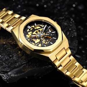Macro view of gold skeleton automatic watch with octagonal bezel on black stones