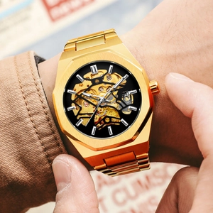 Close-up of gold skeleton automatic watch with octagonal bezel on a male wrist