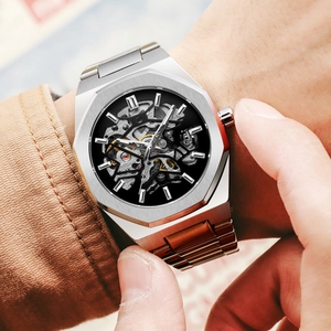 Macro detail of men's mechanical watch with octagonal silver bezel and hollow dial