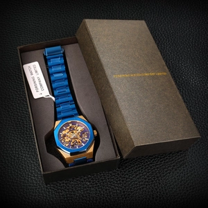 Close-up of skeleton mechanical watch in blue and gold finish within a luxury gift box