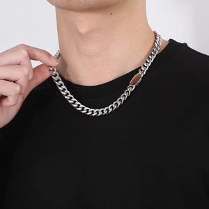 Close-up of polished silver Cuban link chain necklace on a male model's neck