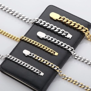 Detailed close-up of Cuban link chains in gold and silver finish on a black background