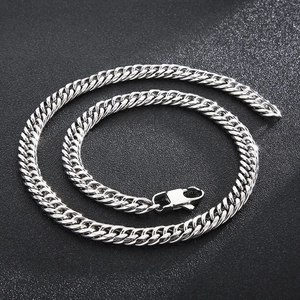 Detail shot of silver Cuban link chain necklace with lobster clasp on dark background