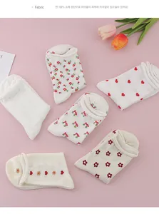 Close-up of 6 pairs of cotton socks with heart and floral patterns on pink background