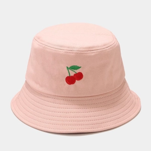 Gros plan d'un bob rose avec broderie de cerises et texture en toile de coton
