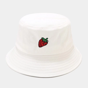 Détail d'un bob en coton blanc avec broderie de fraise rouge et bord cousu avec précision