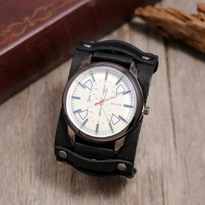 Close-up of a punk leather watch with metal rivets on a vintage wooden tabletop