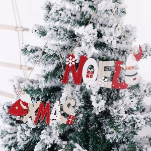 Ornamenti natalizi in legno con disegni di Babbo Natale appesi a un albero di Natale innevato