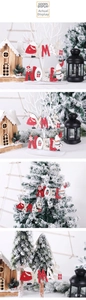 Dettaglio di ornamenti natalizi in legno con scritte XMAS e NOEL su un albero di Natale
