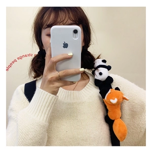 Cute panda and fox plush brooches shown as decorative charms on a backpack strap