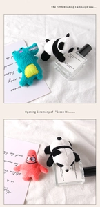 Detail of plush animal brooches featuring panda and crocodile characters on soft fabric