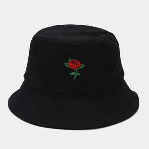 Close-up of vibrant red rose embroidery on a black cotton bucket hat with fine stitching