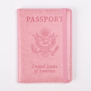 Detalle de funda para pasaporte rosa en cuero con emblema de EE. UU. y banda elástica