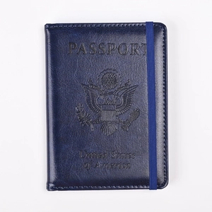 Detalle de funda de pasaporte azul oscuro en cuero PU con sello grabado y elástico