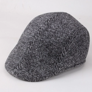 Detailed close-up of grey and black herringbone twill fabric on a vintage flat cap