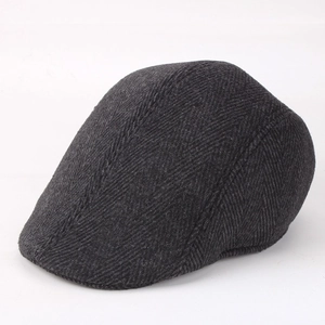 Detail of dark grey herringbone knit newsboy cap showing thick wool blend texture