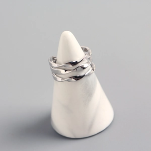 Close-up of S925 sterling silver multi-layer twisted wave ring on marble stand