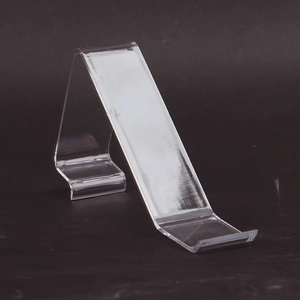 Detailed side view of clear acrylic S-shaped shoe display stand for retail counters