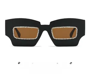 Close-up of black oversized square sunglasses with sparkling rhinestone inlay and brown lenses