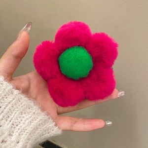 Detail of plush daisy hair claw with vibrant magenta petals and green center