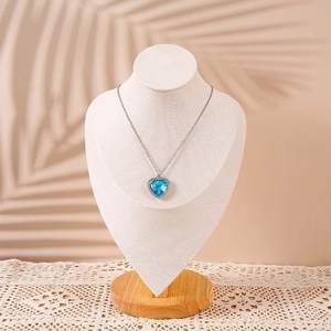 Elegant solid wood neck display stand featuring a blue heart pendant necklace with palm leaf shadow