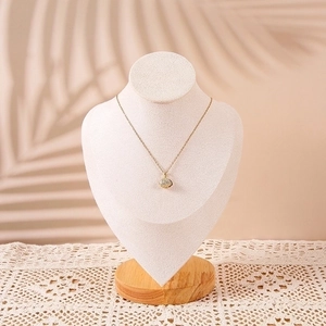 Close-up of golden necklace with pave diamond pendant on premium wooden bust display