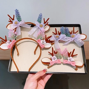 Detail view of festive reindeer antler headbands and clips with bows on a tray
