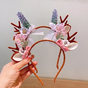 Detail of Christmas reindeer antler headband with fabric flowers and ribbon bows