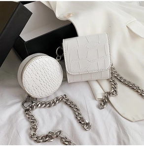 Macro shot of white crocodile embossed texture on mini bags with thick silver metal chain