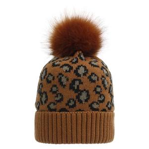 Detail view of the thick leopard jacquard knit pattern and fluffy brown faux fur pompom