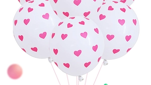 Close-up of white latex balloons featuring pink heart prints for wedding decorations