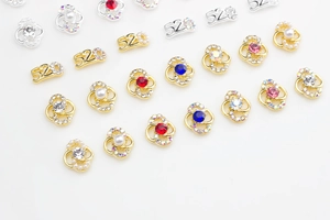Macro shot of 520 number and knot-shaped nail charms with pearls and colorful rhinestones