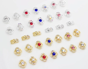 Macro view of alloy 520 and floral nail art charms with colorful rhinestones and pearls