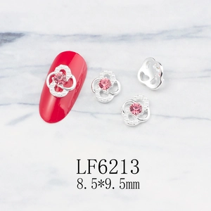 Detail of flower nail charm with pink rhinestone and pearls on silver alloy base