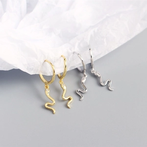 Macro detail of S925 sterling silver snake earrings in gold and silver finish