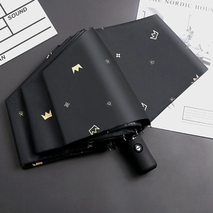 Automatic folding umbrella in black with gold crown pattern and UV protection coating
