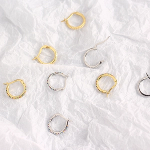 Detailed close-up of S925 sterling silver hoop earrings with colorful zircon on wrinkled paper
