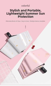 Detail of pink and white folding umbrellas with crown and heart patterns and matte handles
