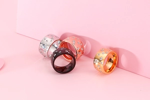 Close-up of four-color stainless steel wide bands set with multiple round zircons