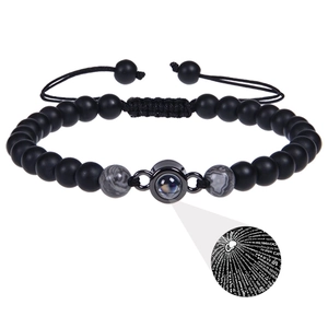 Detail of 100 languages projection stone bracelet with adjustable braided rope and beads
