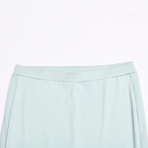 Detailed view of elastic waistband on light blue stretch pants showing smooth fabric texture