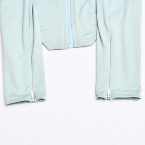 Detail shot of the zipper closure on the light blue long sleeve top hem and cuff