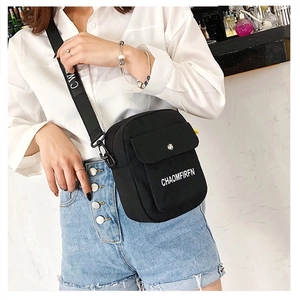 Front view of black canvas crossbody bag with white letter prints and flap pocket detail