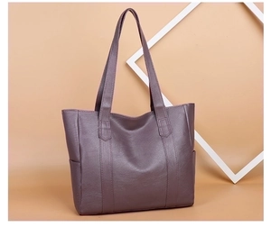 Detailed view of dark grey PU leather tote bag with sturdy handles and textured surface